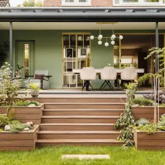 Schöne Ideen für einen kleinen Wintergarten: grüne Wände, bequeme Sitzmöbel und ein Essbereich mit moderner Beleuchtung.