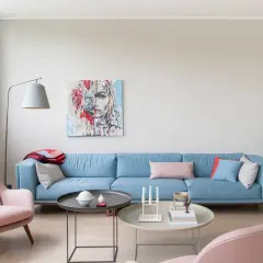 Ein hellblaues Sofa mit rosa Akzenten und einem abstrakten Gemälde. Welche Farbe passt zu altrosa? Hier wird es gezeigt.