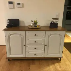 Ein Sideboard mit Eichenholzplatte, das rustikal und modern kombiniert. Darauf ein Osterhase, ein Bügeleisen und ein Telefon.